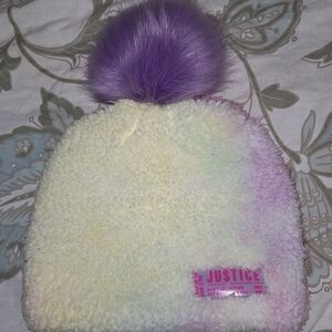 A Justice fuzzy tie dyed hat with a pompom. Warm, cozy, festive, colorful